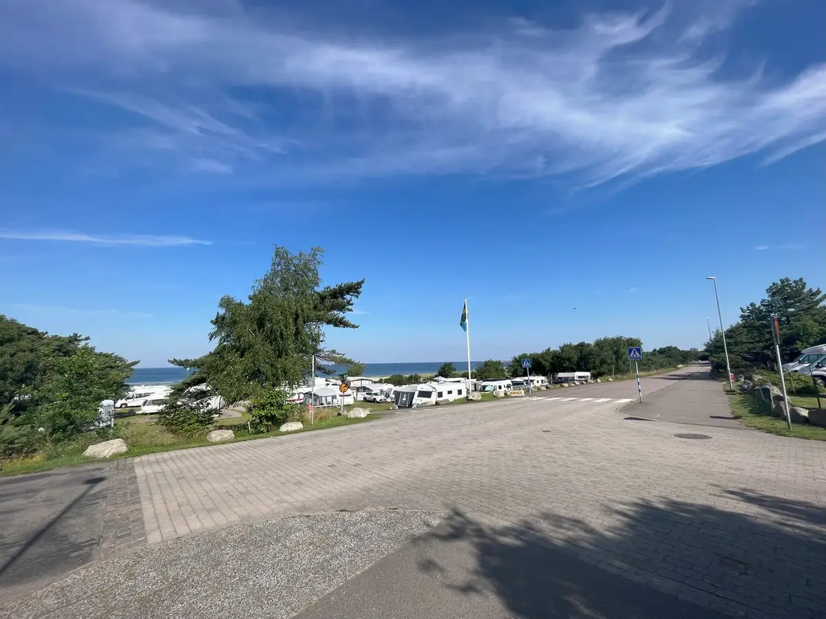 Campingplatser med husvagnar och havet bakom