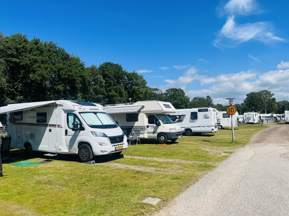 Husbilar på rad längs en väg på campingen