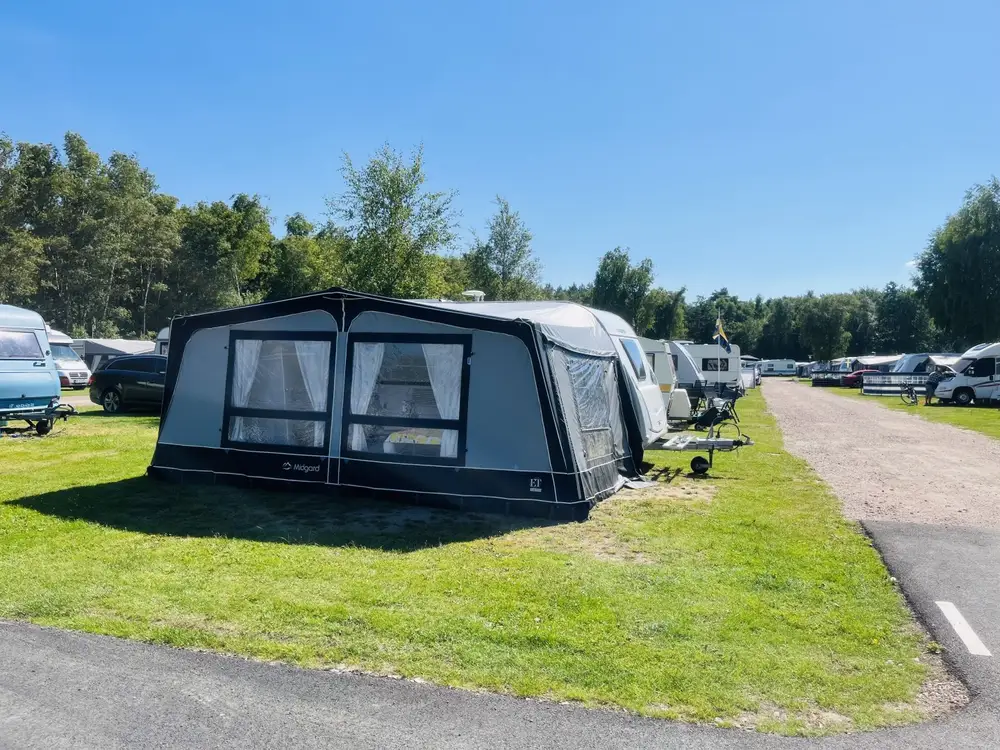 Campingtomt med förtält på gräsmatta